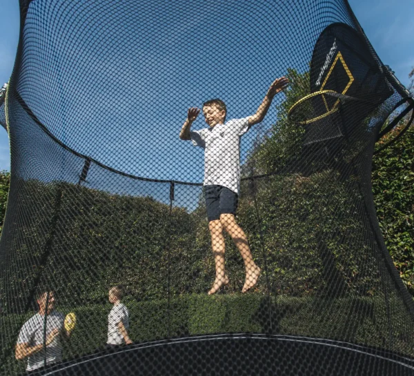 Chlapec skáče na trampolíně Springfree R54 Compact Round